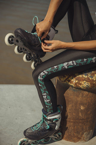 pure by luce sustainable black Rene Joburg leggings with printed side stripes inspired by South Africa worn by a girl tying her inline skates