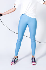 pure by luce sustainable light blue unicolour Noor Sky leggings worn by a girl ropeskipping with the Yattou White sports T-shirt with cut-out sleeves