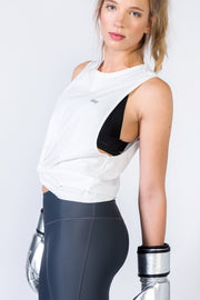 pure by luce sustainable Rehanna White cutout sports top with dark grey unicolour Noor Petrol leggings with booty contouring worn by a girl wearing boxing gloves
