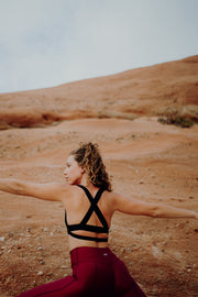 pure by luce sustainable Charo Black bra top: black low-support sports bra and the dark red unicolour Noor Ruby leggings with booty contouring