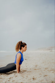 pure by luce sustainable Gugu Blue sports crop top with the dark grey unicolour Noor Petrol leggings with booty contouring worn in the yoga position upward facing dog