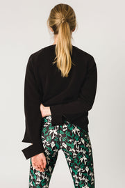 pure by luce sustainable athleisure Nina Black sweater with cut our sleeve cuffs and the green all-over printed Naomi Joburg leggings