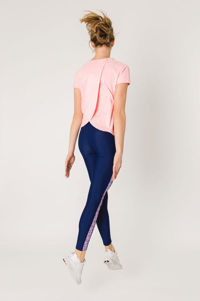 pure by luce sustainable Susan Pink sports T-shirt with open back with dark blue Rene Paarl leggings with printed side stripes