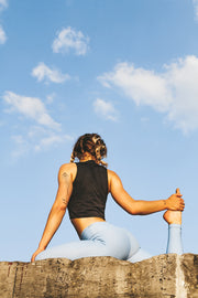 Laura Vantorre in pure by luce sustainable Gugu Black sports crop top with the light blue unicolour Noor Sky leggings with booty contouring in a yoga position