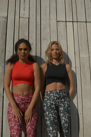 pure by luce sustainable Gugu Black sports crop top with the green all-over printed Naomi Joburg leggings and Gugu Red sports crop top with the red all-over printed Naomi Cape Town leggings